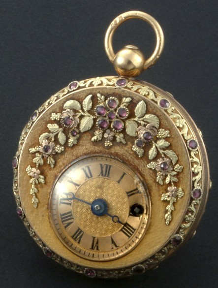 1815年誕生的懷表，黃金制成，雕飾花卉圖案鑲嵌石榴石。機刻雕花偏心表盤綴有羅馬數(shù)字。